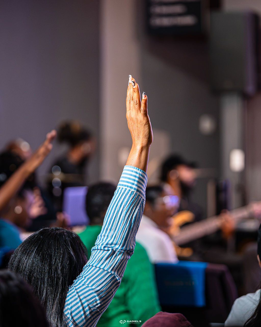 A worshipper with her hand raised during service